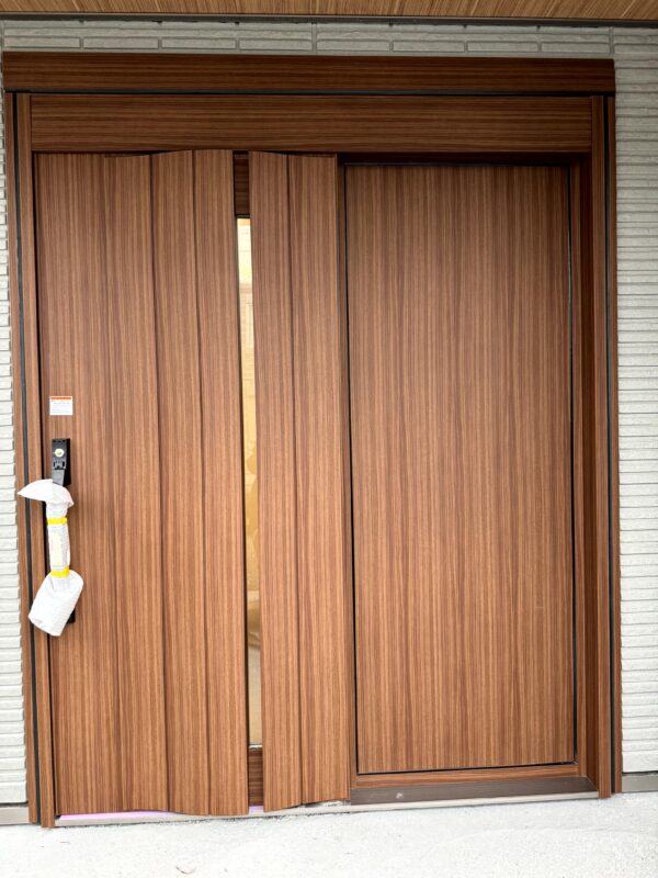 玄関ドアに木目シートを施工